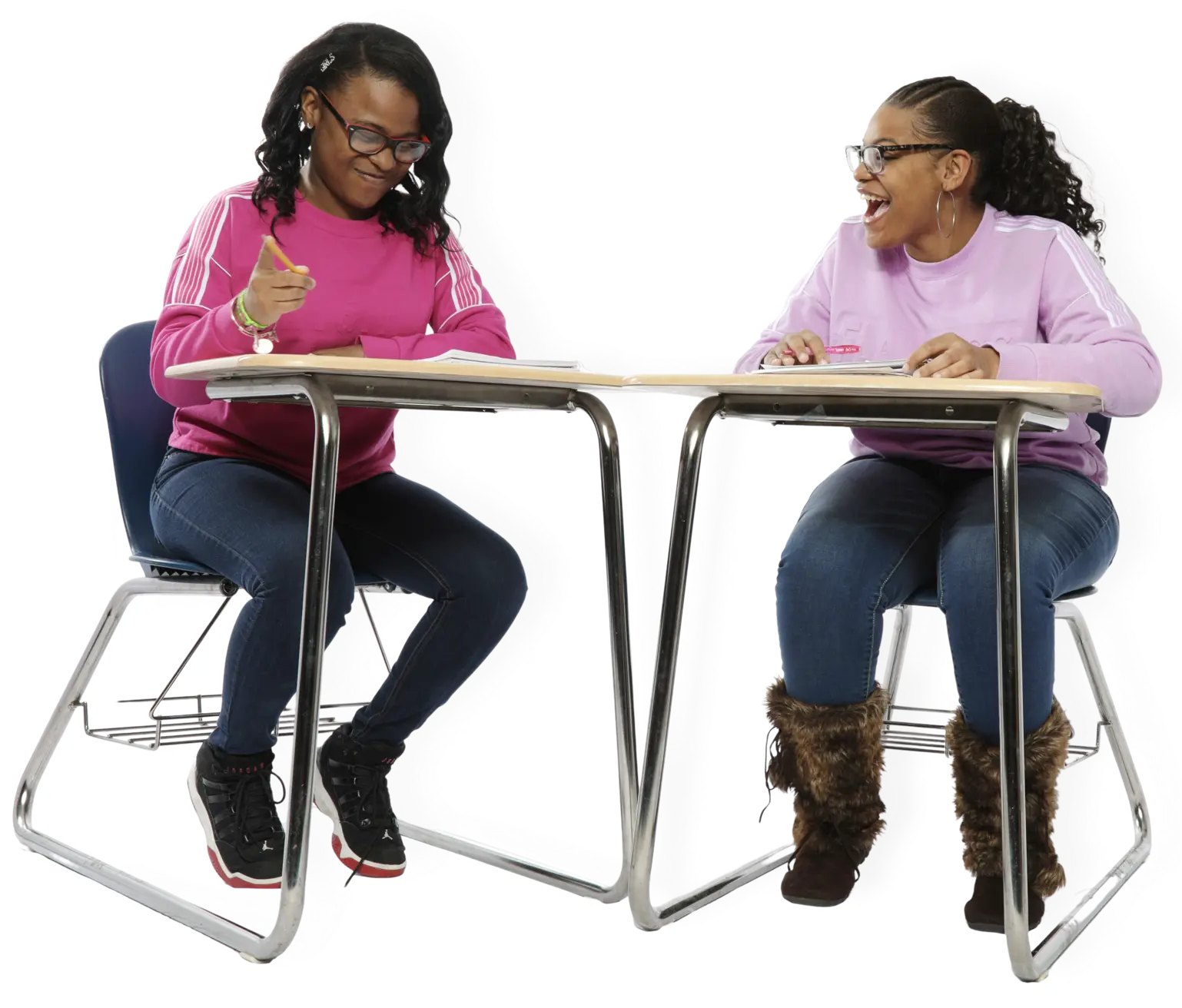 Two teen girls sitting desks working on School-Connect handout